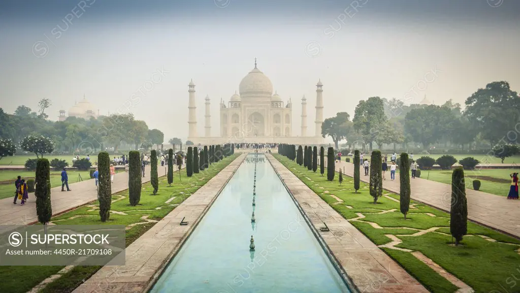 Exterior view of the Taj Mahal palace and mauseleum, a UNESCO world heritage site, a palace with white marble walls inlaid with decorative detail.