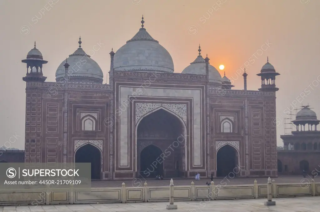 Exterior view of the Taj Mahal palace and mauseleum, a UNESCO world heritage site, a palace with white marble walls inlaid with decorative detail.