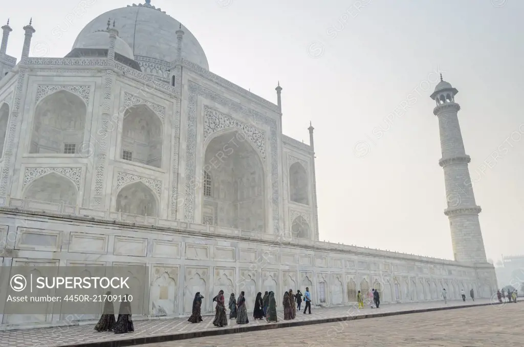 Exterior view of the Taj Mahal palace and mauseleum, a UNESCO world heritage site, a palace with white marble walls inlaid with decorative detail.