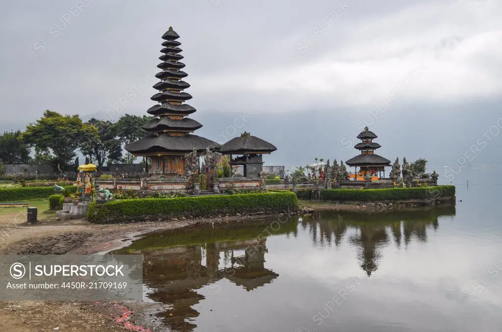 Balinese Hindu Temple, Ulu Danu Beratan, traditional architecture and tall towers with tiered tapering roofs in a valley on the shores of Lake Bratan.