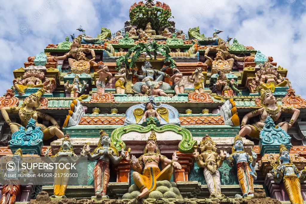 Low angle exterior view of facade of Hindu Temple decorated with colourful sculptures.