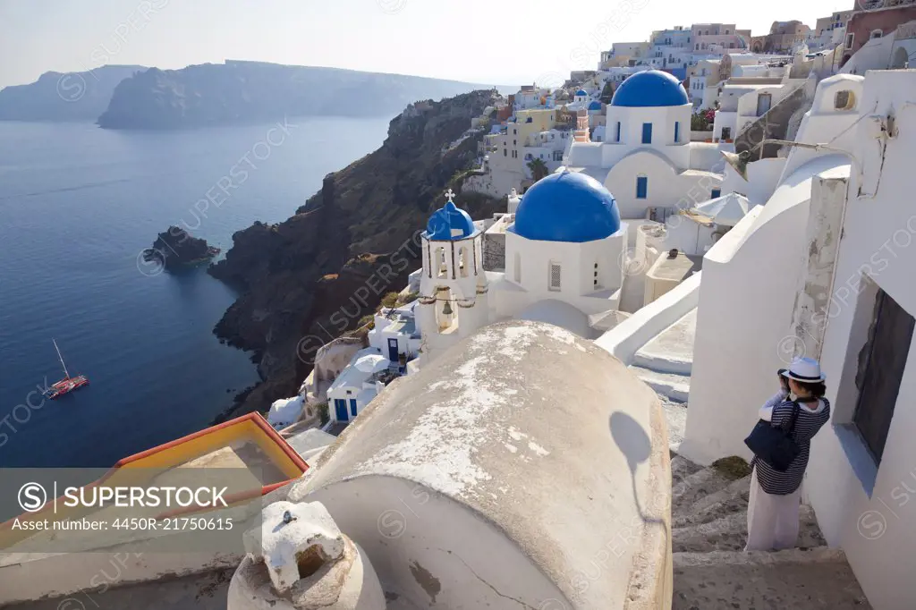 High angle view of traditional white washed church with bright blue dome on the island of Santorini, Greece.