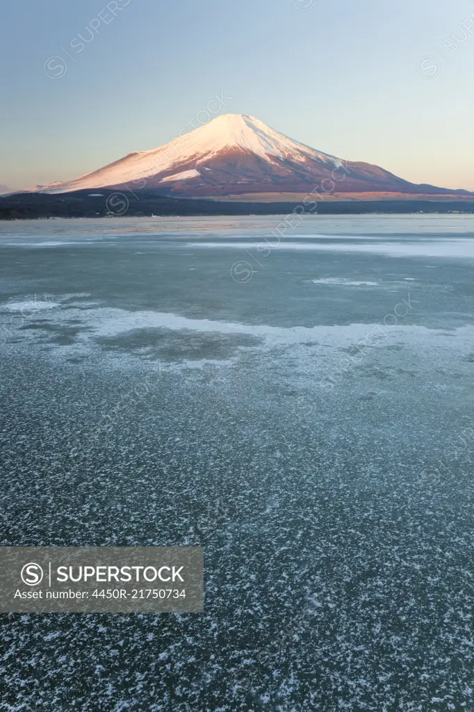 Ice on Lake Yamanaka with snow covered Mount Fuji in background, Japan.