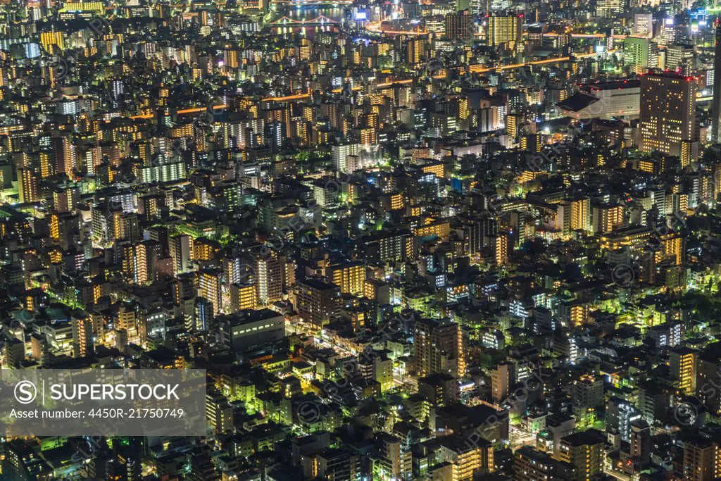 High angle view of cityscape with illuminated skyscrapers at dusk.