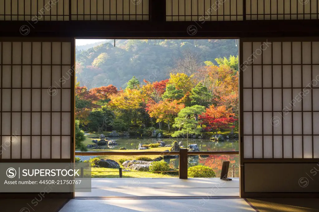 View through traditional Japanese sliding door into an autumn park landscape.