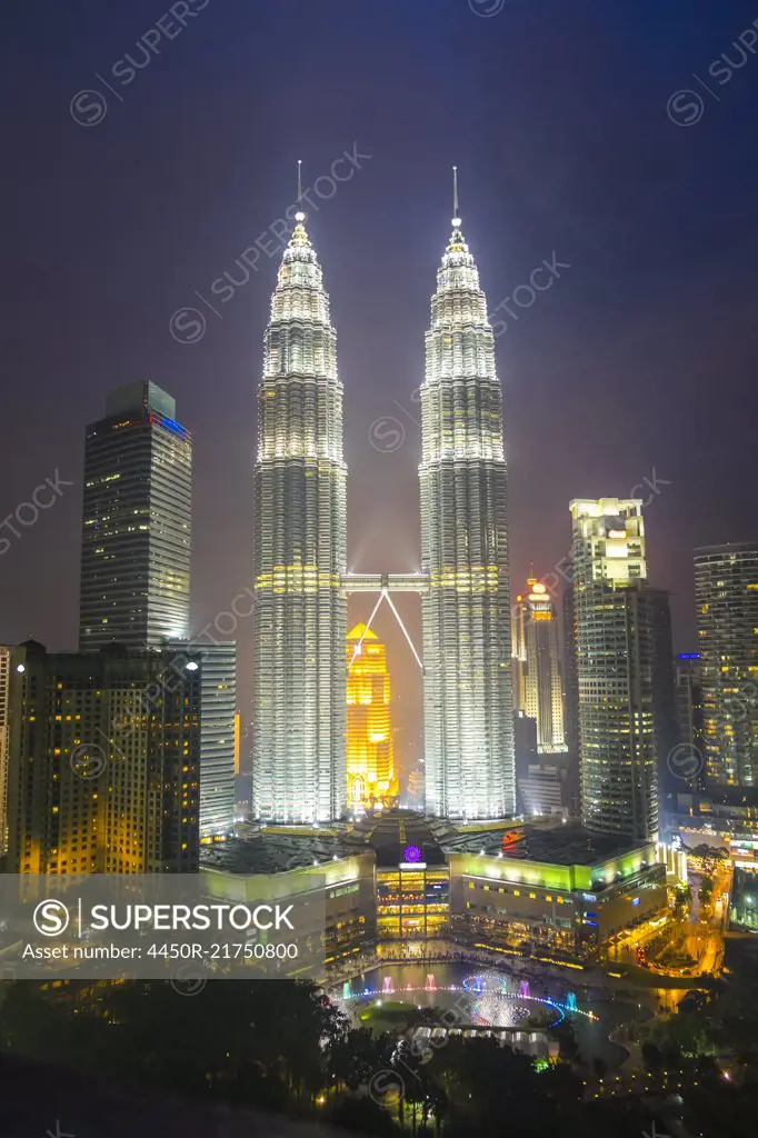 Cityscape of Kuala Lumpur in the evening, with the illuminated Petronas Towers in the distance, Malaysia.