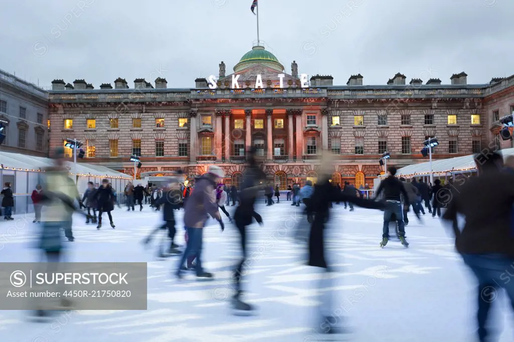 Ice skaters on the ice rink in the courtyard of Somerset House, London, UK.