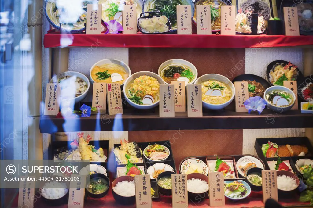 High angle view of a selection of bowls with traditional Japanese foods on shelves.