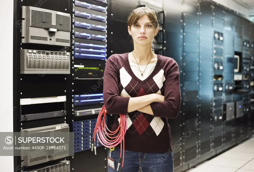 Portrait of female technician working in a large computer server room.