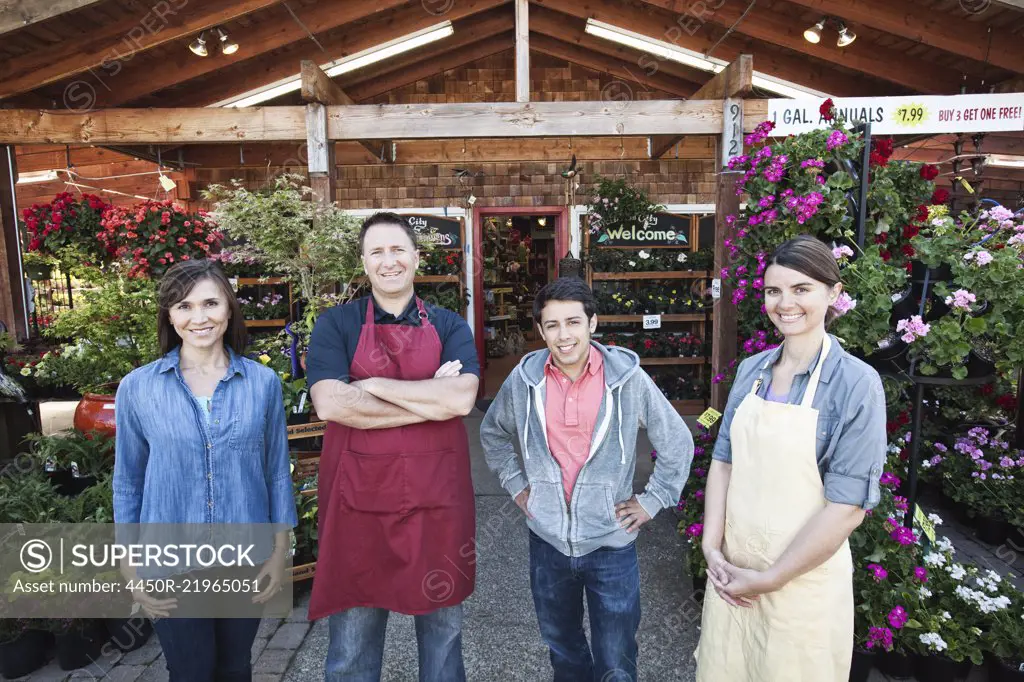 Plant nursery store owners and employees standing in a row in front the store. 