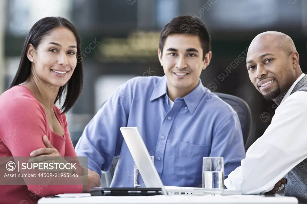 Mixed race team of business people at a table in a business centre.