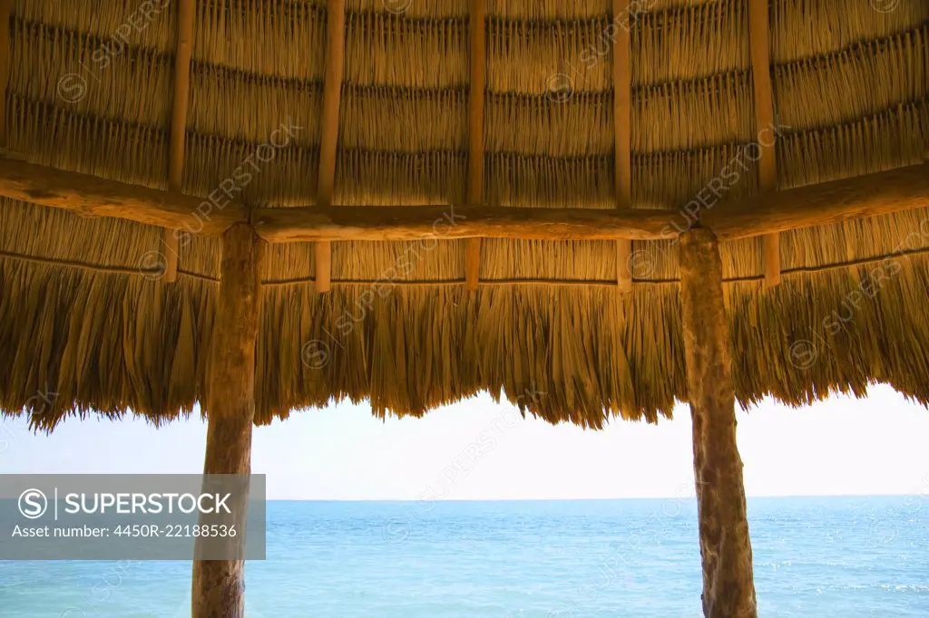 A typical thatched roof cabana on an ocean beach in the Caribbean