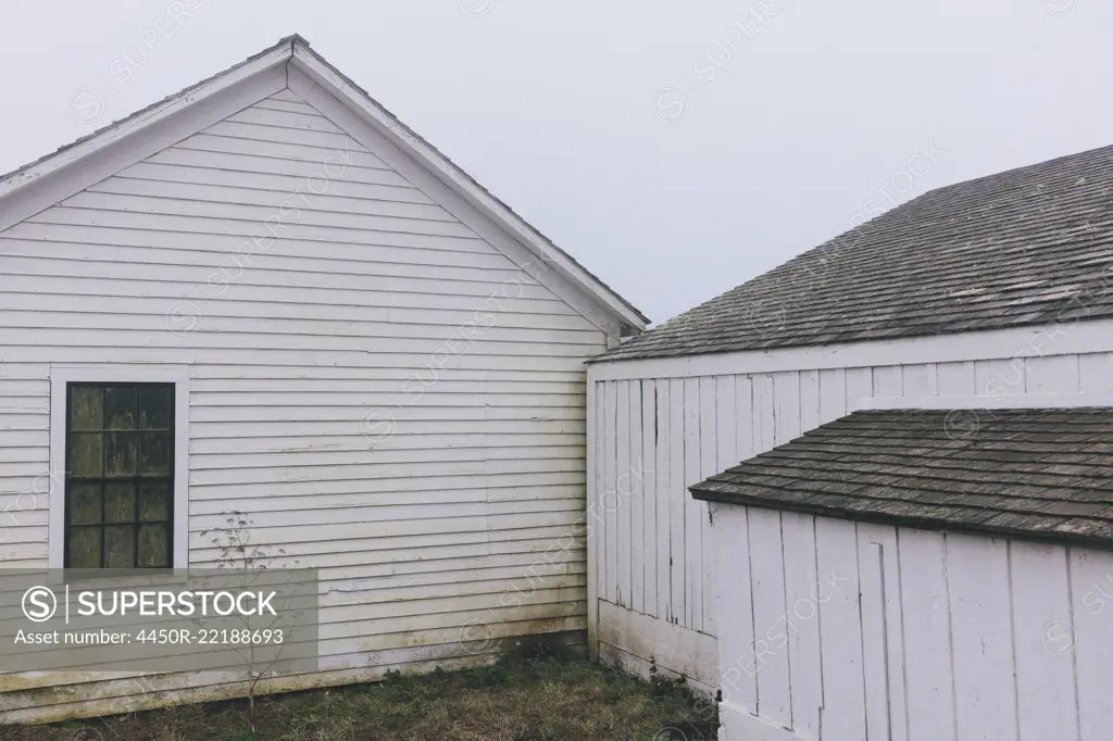 Outbuildings and barn on farm in dense fog in California, USA.