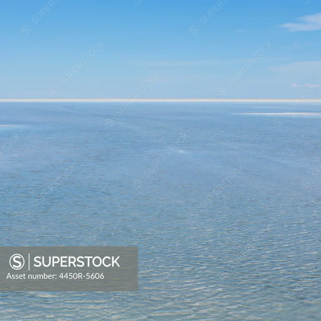 The view across the flooded Bonneville Salt Flats, at dusk. Flat landscape. A white line marking the horizon.