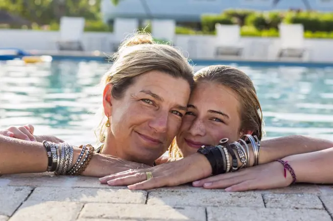 Mother and her 13 year old daughter in pool smiling