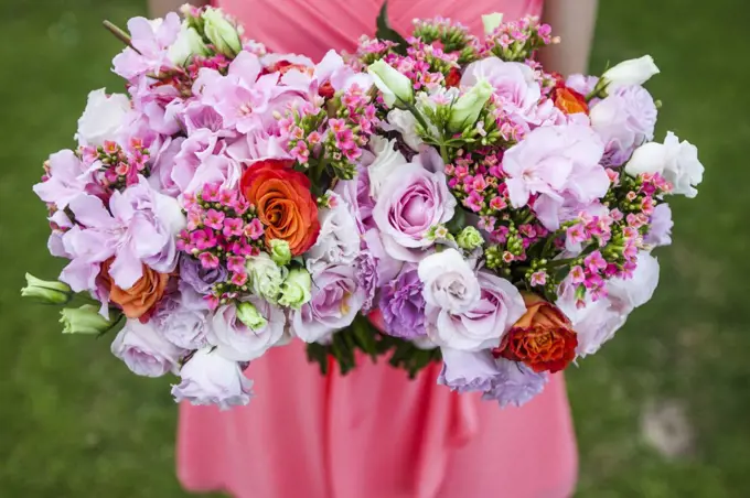 High angle close up of woman holding two bouquets of flowers with pink roses.