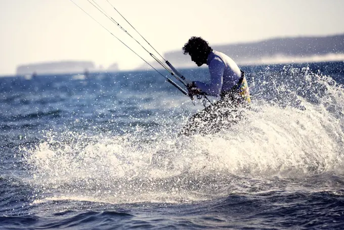 Side view of man kitesurfing on the ocean.