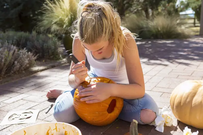 11 year old girl carving a pumpkin