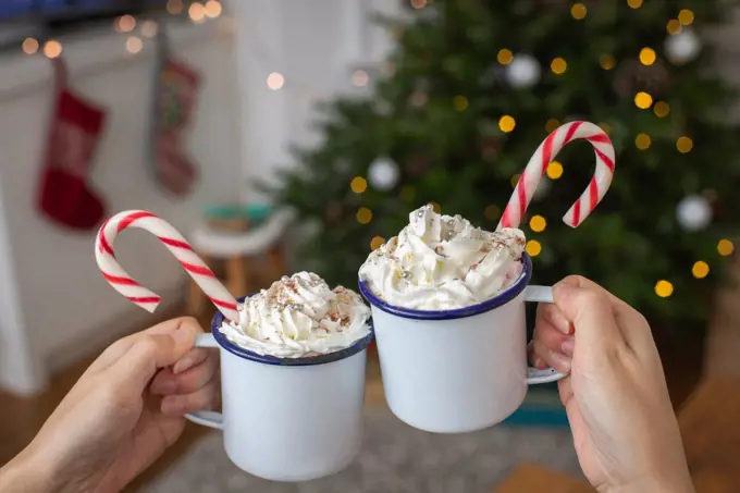 Christmas, mugs of egg nog with whipped cream and candy canes. 