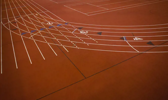 A red running track, athletics ground, a corner section of track marked with lanes