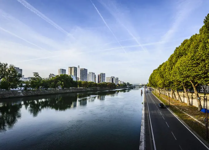 View along the River Seine, a road by the water, high rise buildings. 