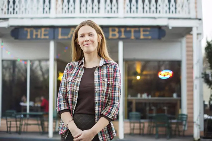 A coffee shop and cafe in High Falls called The Last Bite. A woman standing outside a high street cafe. New York, USA