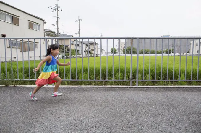 A young girl running along a footpath.