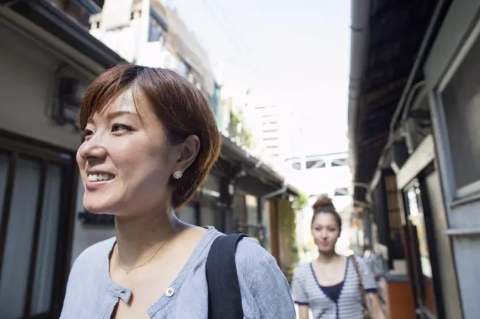 Two women standing outdoors, smiling.