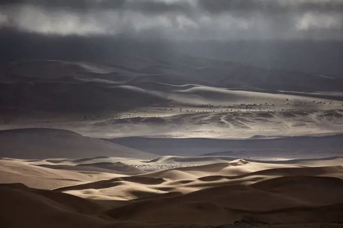 Sand dunes under a stormy sky.