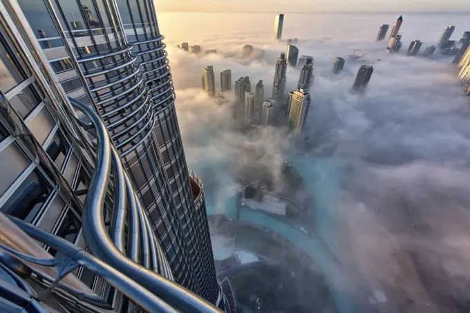 Aerial view of cityscape with skyscrapers above the clouds in Dubai, United Arab Emirates.