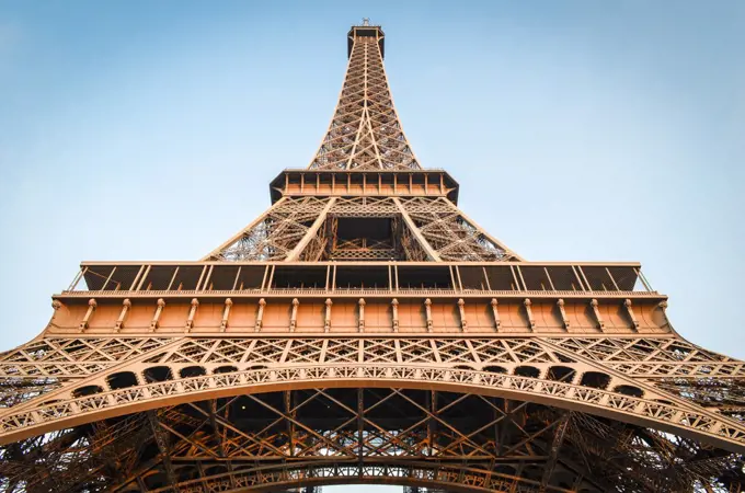 Low angle view of the Eiffel Tower in Paris,  Champs de Mars against a blue sky.