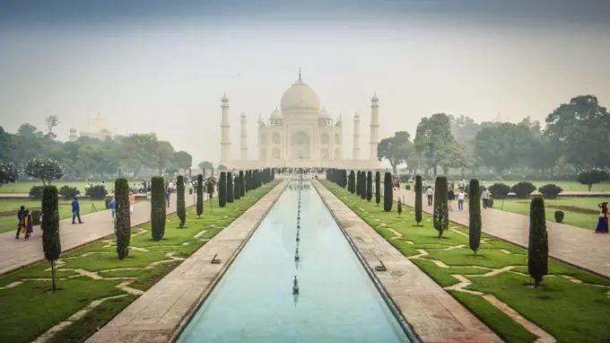 Exterior view of the Taj Mahal palace and mauseleum, a UNESCO world heritage site, a palace with white marble walls inlaid with decorative detail.