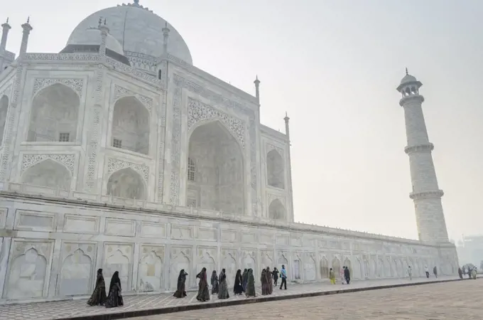 Exterior view of the Taj Mahal palace and mauseleum, a UNESCO world heritage site, a palace with white marble walls inlaid with decorative detail.