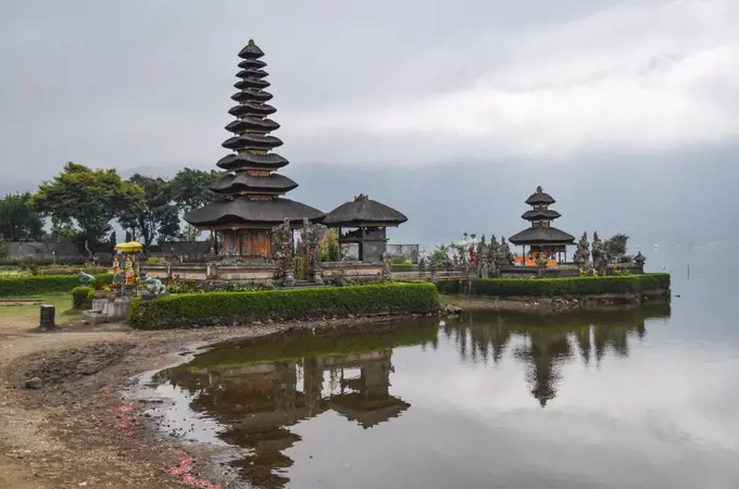 Balinese Hindu Temple, Ulu Danu Beratan, traditional architecture and tall towers with tiered tapering roofs in a valley on the shores of Lake Bratan.