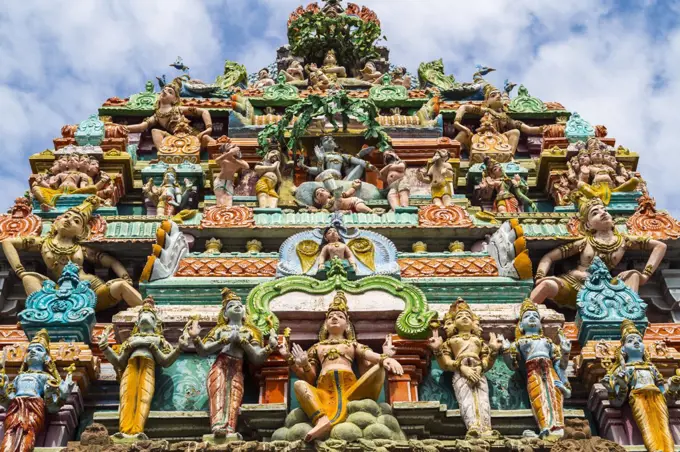 Low angle exterior view of facade of Hindu Temple decorated with colourful sculptures.