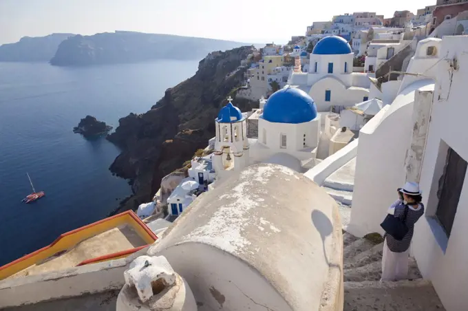 High angle view of traditional white washed church with bright blue dome on the island of Santorini, Greece.