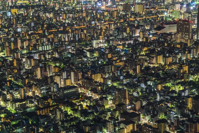 High angle view of cityscape with illuminated skyscrapers at dusk.