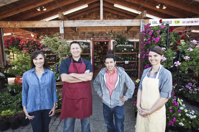 Plant nursery store owners and employees standing in a row in front the store. 