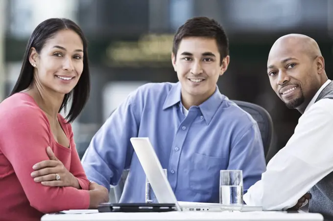 Mixed race team of business people at a table in a business centre.