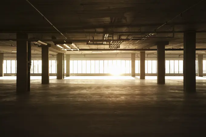 An empty raw business space ready for occupancy. Low light coming in the windows, lens flare.