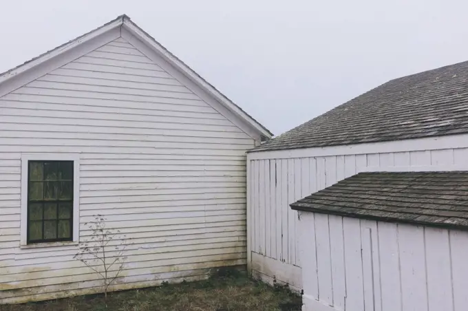 Outbuildings and barn on farm in dense fog in California, USA.