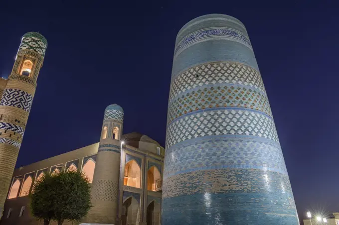 The historic mosque buildings with Kalta Minor minaret in the centre of the town of Khiva, Uzbekistan at night.