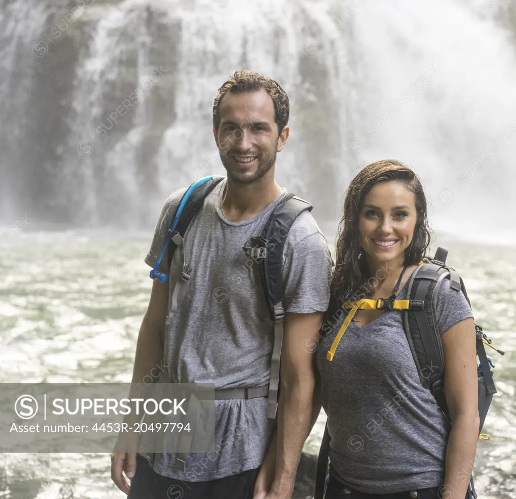 Couple smiling near waterfall