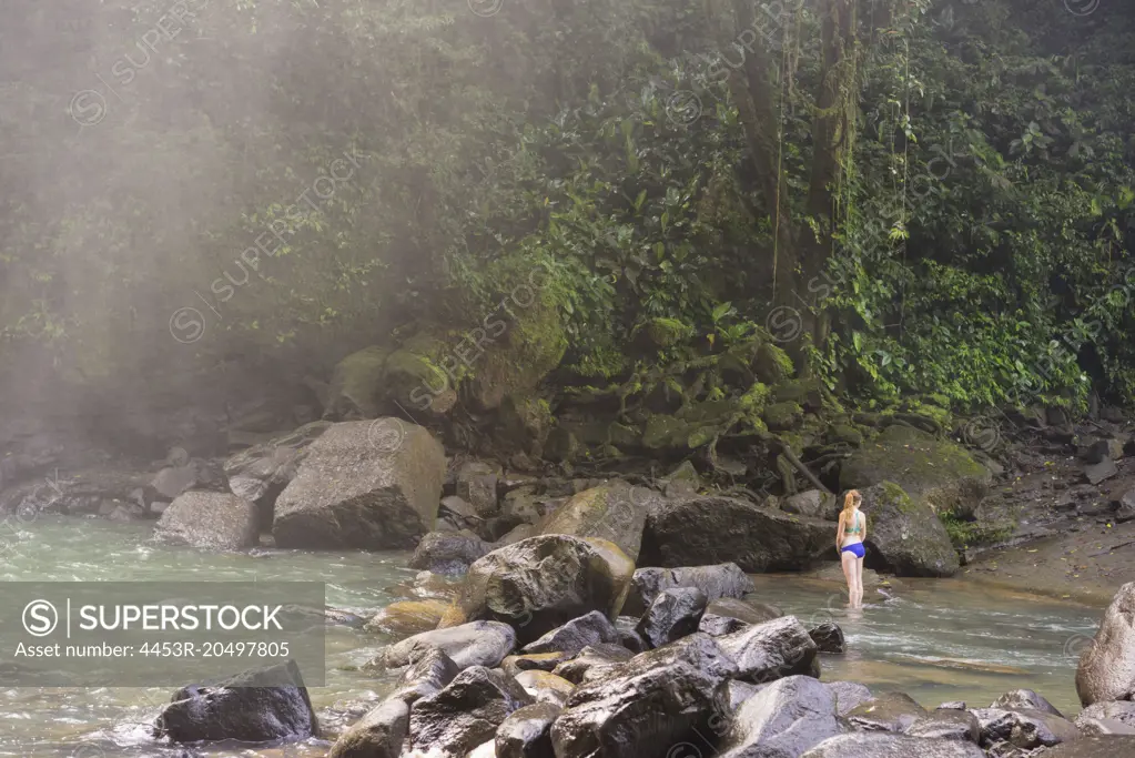 Woman standing in jungle river