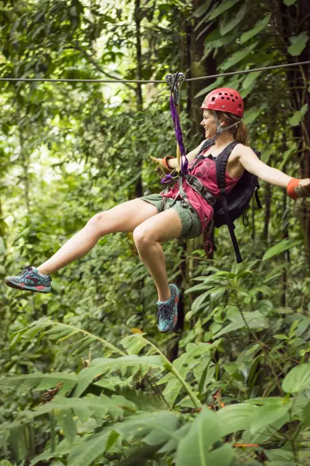 Woman riding zipline in jungle