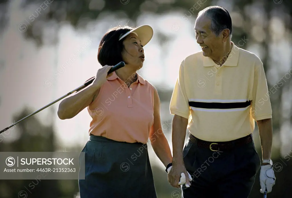 Mature couple having fun while playing golf together.