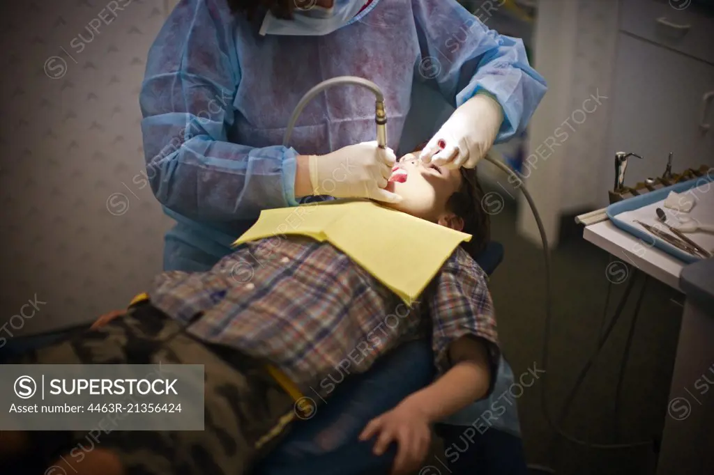 High angle view of a young boy being examined by a dentist.