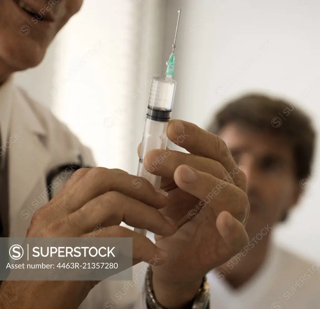 Cropped view of a doctor holding a syringe in his hand.