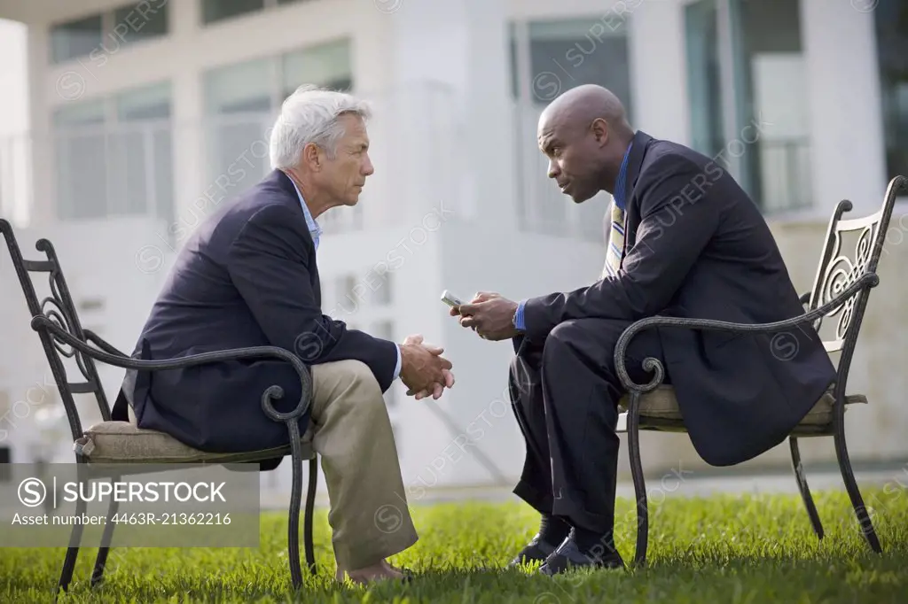 Two businessmen having a discussion outside.