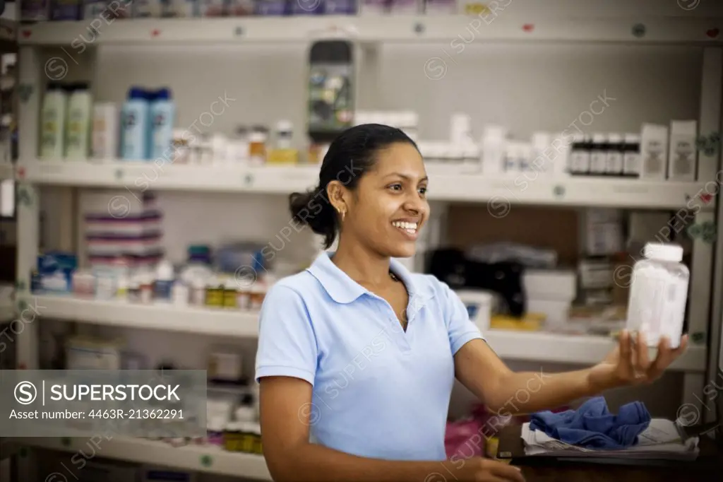 Smiling young woman holding a bottle